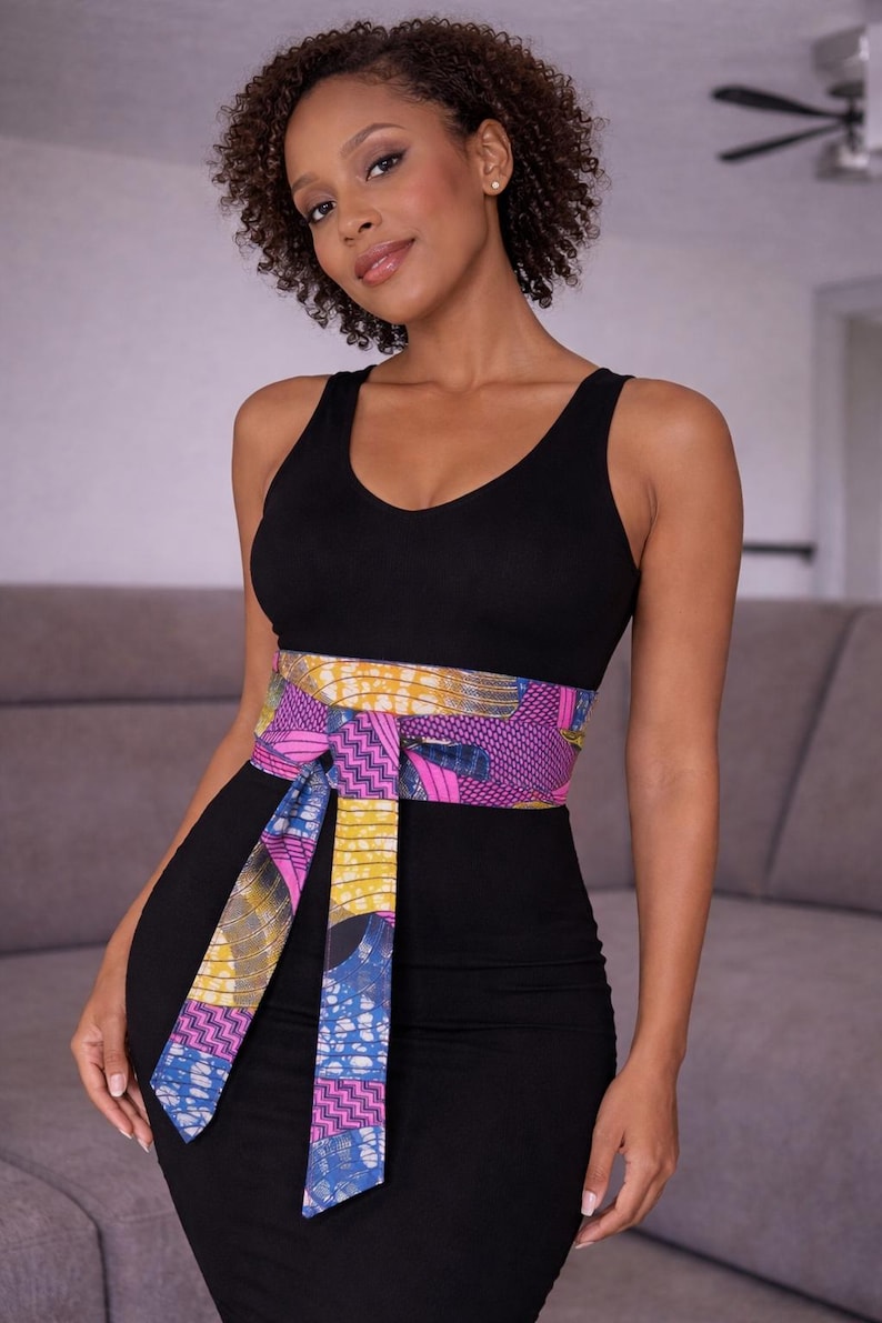 Colorful African Ankara print side of a reversible obi belt tied around a denim dress mannequin, vibrant and stylish.