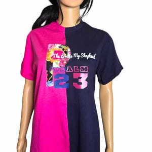 May include: A pink and navy blue t-shirt with a floral design on the left side and the text "The Lord is My Shepherd" and "PSALM 23" on the right side.