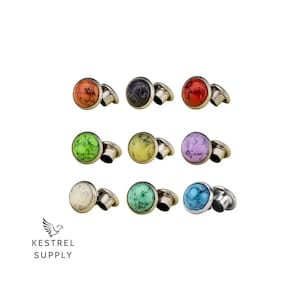 May include: Assortment of 10 colourful round gemstone plugs with silver metal backing. The plugs are in various colours including green, blue, orange, purple, and white.