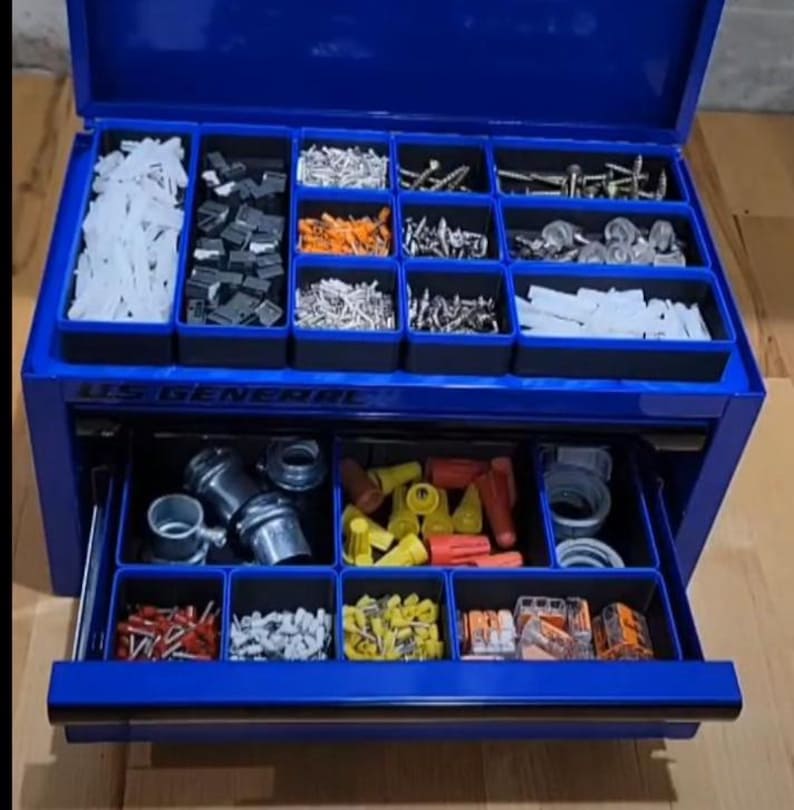 May include: A blue US General metal tool chest with an open lid and one extended drawer. The interior features black plastic organizers filled with various hardware, including white wall anchors, metal screws, wire connectors, and electrical terminals.