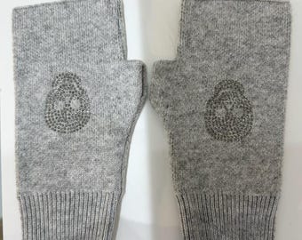 May include: A pair of gray fingerless gloves with a sparkly skull design on each glove.