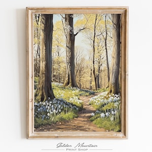 May include: A painting depicting a forest path lined with trees and white flowers. The path leads into the distance, with sunlight filtering through the trees. The painting is framed in a light wood frame.
