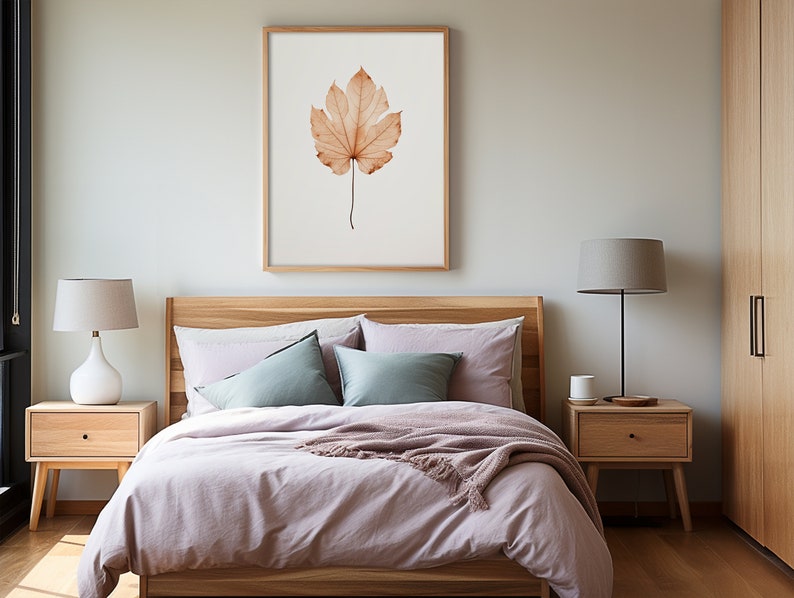 May include: A bedroom scene featuring a bed with light purple bedding, pillows, and a wooden headboard. Two wooden nightstands with lamps flank the bed. A framed print of a leaf hangs above the bed, and a wooden wardrobe is visible.