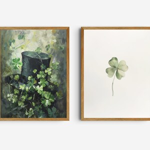 May include: Two framed prints, one with a black top hat surrounded by green shamrocks and the other with a single green four-leaf clover.