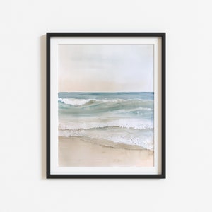 K&ouml;nnte beinhalten: Ein gerahmtes Aquarellbild eines Meeresbildes mit blauen und gr&uuml;nen Wellen, die an einem Sandstrand brechen.