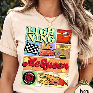 Puede incluir: Camiseta color crema con un dise&ntilde;o gr&aacute;fico colorido con las palabras "Lightning McQueen" y otro texto. El dise&ntilde;o incluye im&aacute;genes de un coche de carreras, una bandera a cuadros y un trofeo. La camiseta tiene mangas cortas.