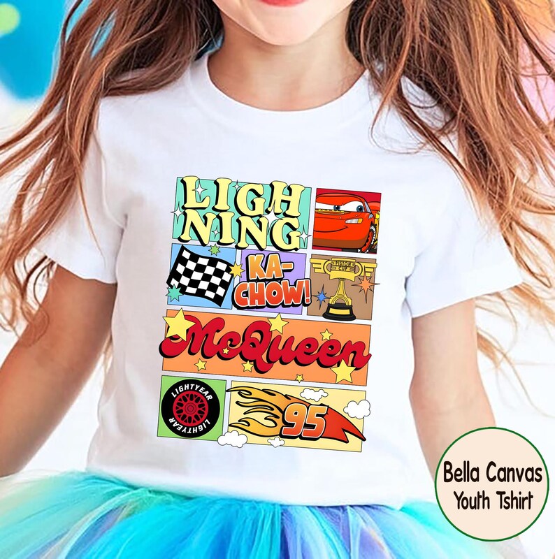 Puede incluir: Camiseta blanca para ni&ntilde;os con un dise&ntilde;o gr&aacute;fico colorido. El dise&ntilde;o incluye el texto "Lightning Ka-Chow! McQueen", un coche de carreras, una bandera a cuadros, un trofeo y el n&uacute;mero 95. La camiseta tambi&eacute;n tiene el texto "Lightyear".