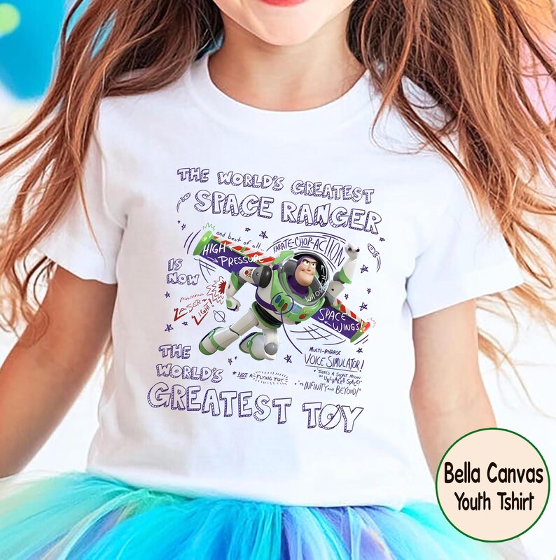 Op de afbeelding: Witte kindert-shirt met Buzz Lightyear uit Toy Story. De afbeelding bevat de tekst "THE WORLD'S GREATEST SPACE RANGER" en "THE WORLD'S GREATEST TOY". Het ontwerp bevat ook de zinnen "High Pressure" en "Space Wings".