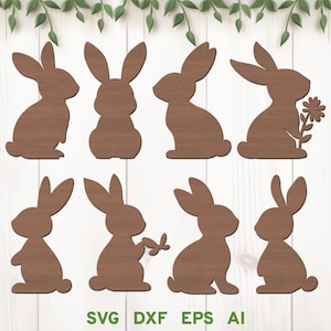 Può includere: Una collezione di otto sagome di conigli in legno in varie pose. I conigli sono di colore marrone medio e hanno una texture a venatura del legno. Alcuni conigli tengono in mano un fiore o una farfalla. Il testo "SVG DXF EPS AI" è visualizzato nella parte inferiore dell'immagine.