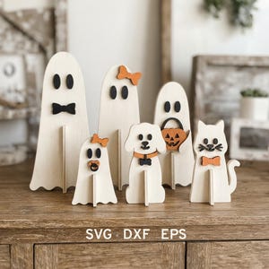 Puede incluir: Un conjunto de seis decoraciones de Halloween de madera independientes que incluyen tres fantasmas, un perro, un gato y un fantasma con un cubo de calabaza. Las figuras tienen detalles en negro y naranja. El texto dice SVG DXF EPS.