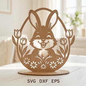 May include: Wooden Easter bunny decoration with a smiling face, surrounded by tulips and flowers. The bunny is inside an oval frame, and the base is round. The text "SVG DXF EPS" is at the bottom.