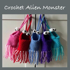 May include: Five crocheted alien monster ornaments hanging from hooks. The ornaments are in pink, red, blue, purple, and turquoise. Each ornament has two googly eyes and a fringe.