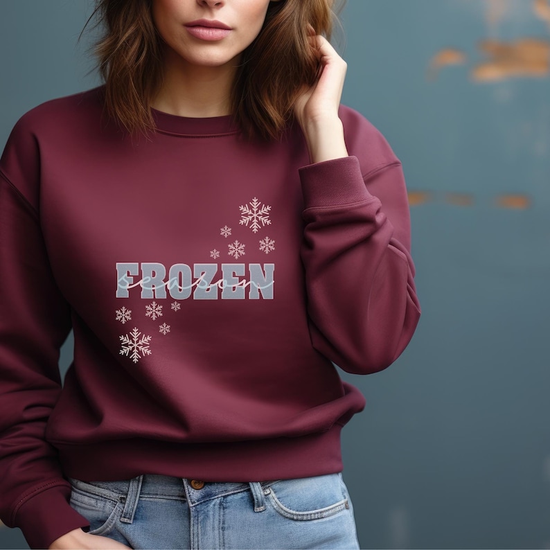 May include: A maroon sweatshirt with the text "FROZEN season" in white and gray lettering with a snowflake design.