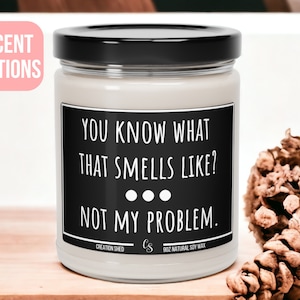 May include: A white candle with a black label that reads "You know what that smells like? Not my problem." The candle is 9 oz and made with natural soy wax.