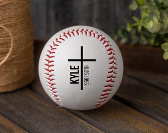May include: White baseball with red stitching and a black cross with the name "KYLE" and the date "10.25.1995" printed on it.