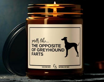 Może przedstawiać: Zapachowa, bursztynowa świeca w szklanym słoiku z czarną pokrywką. Etykieta głosi "smells like... THE OPPOSITE OF GREYHOUND FARTS" z sylwetką charta. Wykonana z naturalnego wosku sojowego.