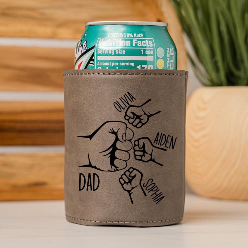 May include: A brown leather can cooler with a design of four fists bumping each other. The names "DAD", "OLIVIA", "AIDEN", and "SOPHIA" are written around the fists.