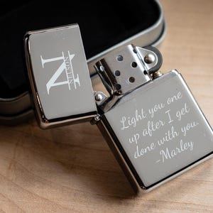 Pu&ograve; includere: Un accendino argentato con un'iscrizione personalizzata che recita "Light you one up after I get done with you. -Marley". L'accendino ha anche un monogramma con l'iniziale "N" e il nome "NELSON" inciso sul lato.