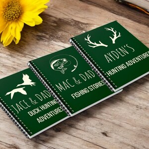 May include: Three green spiral bound journals with white text and illustrations. The journals are titled "Jace & Dad Mac & Dad Duck Hunting Adventures", "Jace & Dad Mac & Dad Fishing Stories", and "Ayden's Hunting Adventures".