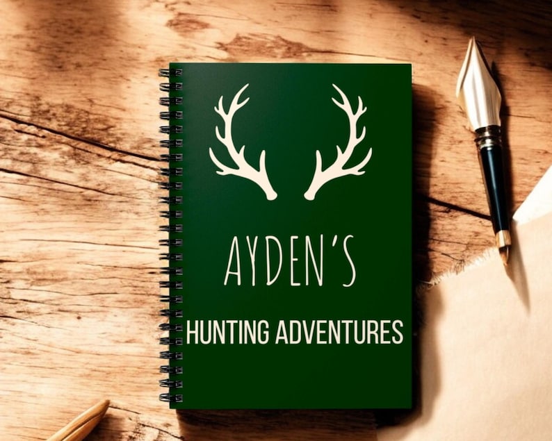 May include: A green spiral bound notebook with a white antler design and the text "AYDEN'S HUNTING ADVENTURES".