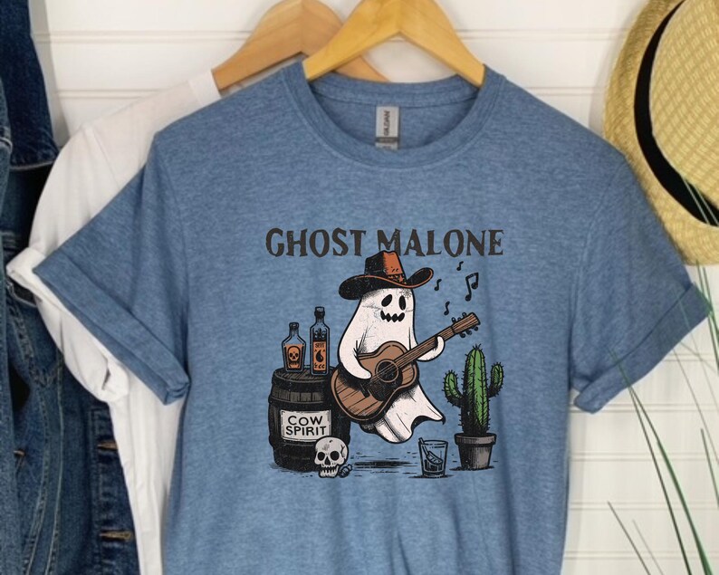 May include: A blue t-shirt with the text "Ghost Malone" printed on it. A cartoon ghost wearing a cowboy hat is playing a guitar and holding a bottle of "Cow Spirit".