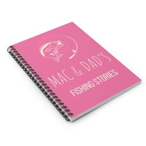 May include: Pink spiral bound notebook with a white illustration of a fish on a fishing line and the text "Mac & Dad's Fishing Stories".