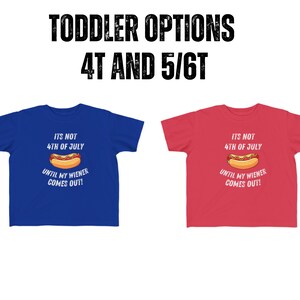 Pode incluir: Duas camisetas para crian&ccedil;as pequenas com um gr&aacute;fico de cachorro-quente e o texto "N&atilde;o &eacute; 4 de julho at&eacute; que meu salsicha saia!" Uma camiseta &eacute; azul e a outra &eacute; vermelha.