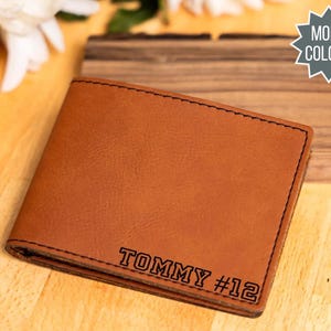 May include: A brown leather wallet with the name "TOMMY #12" engraved on it.