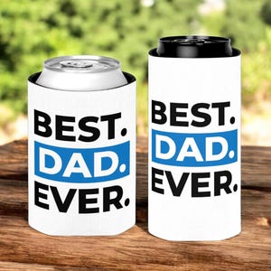 May include: Two white can coolers with black text that reads "BEST. DAD. EVER." The text "DAD" is in a blue rectangle.