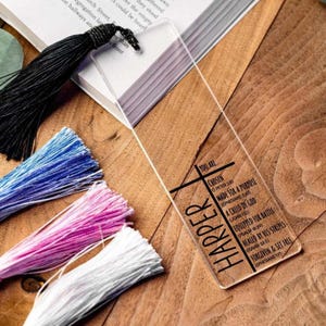 May include: A clear acrylic bookmark with a black cross and the name "HARPER" printed in black. The bookmark also includes a list of bible verses in black text.