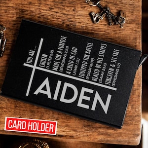 May include: Black card holder with the name Aiden printed in white. The card holder has a cross design with inspirational quotes and bible verses.