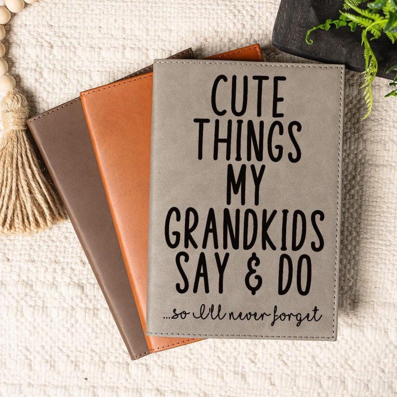 May include: Three gray, brown, and orange leather-bound journals with the text "Cute Things My Grandkids Say & Do...so I'll never forget" printed on the front of the gray journal.
