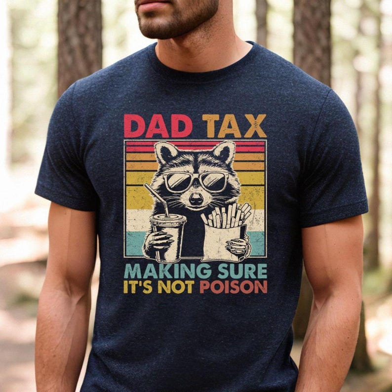 K&ouml;nnte beinhalten: Marineblaues T-Shirt mit einem Waschb&auml;ren mit Sonnenbrille, der ein Getr&auml;nk und Pommes h&auml;lt. Das Shirt hat den Text "DAD TAX" &uuml;ber dem Waschb&auml;ren und "MAKING SURE IT'S NOT POISON" darunter.