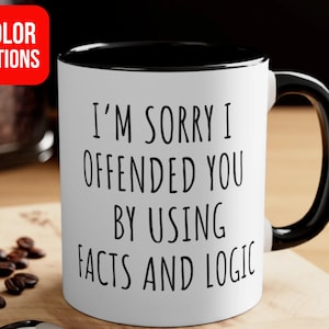 May include: White ceramic mug with a black interior and handle. The mug features the text "I'M SORRY I OFFENDED YOU BY USING FACTS AND LOGIC" in black. A red square with "COLOR OPTIONS" is in the upper left corner.