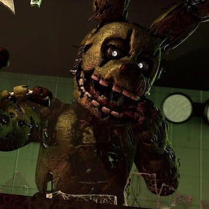 May include: A weathered, olive-green animatronic rabbit figure with a damaged, textured exterior. The character features a wide, toothy grin, glowing white eyes, and exposed mechanical components within its torn, decaying suit structure.