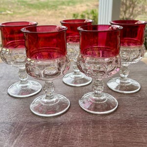 Puede incluir: Juego de cinco copas de vino vintage. Cada copa presenta un cuenco transparente con dibujos y un borde rojo vibrante. Las copas tienen un tallo y una base clásicos, perfectos para servir vino u otras bebidas.