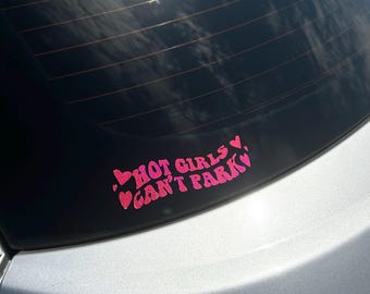 Peut inclure: Un autocollant de voiture rose pailleté avec le texte "Hot Girls Can't Park" et des cœurs.