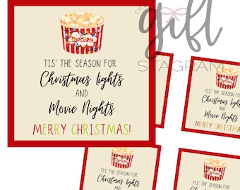 Könnte beinhalten: Festliche Weihnachtskarte mit rotem Rand. Die Karte zeigt eine Illustration eines Popcorn-Eimers mit dem Wort "Popcorn". Der Text auf der Karte lautet: "Es ist die Zeit für Weihnachtslichter und Filmabende. Frohe Weihnachten!"