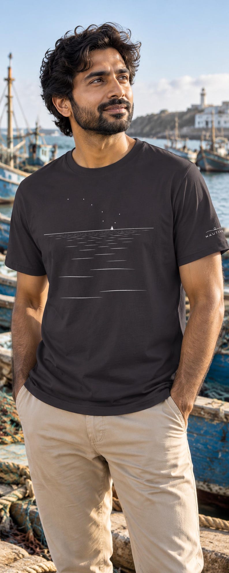 Peut inclure: Un t-shirt &agrave; manches courtes gris anthracite fonc&eacute; orn&eacute; d'un graphique lin&eacute;aire blanc minimaliste repr&eacute;sentant un voilier sur l'eau sous un ciel &eacute;toil&eacute;. La manche gauche porte le texte blanc NAUTIVE avec une petite ic&ocirc;ne de bateau.