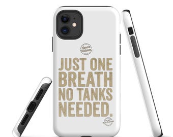 Könnte beinhalten: Eine weiße Smartphone-Hülle mit dem Text "JUST ONE BREATH NO TANKS NEEDED." in einer beigen, abgenutzten Schriftart. Über dem Text befindet sich ein kreisförmiges "Apnea Division"-Logo und darunter ein kleineres, beiges "est. 2019 Pure Freedom"-Logo.
