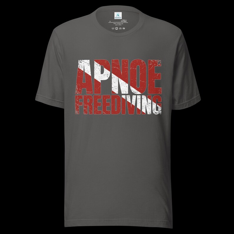 Puede incluir: Una camiseta de manga corta gris oscuro con un estampado gr&aacute;fico desgastado en el pecho. El dise&ntilde;o muestra el texto APNOE FREEDIVING en una fuente negrita y desgastada, superpuesto con un patr&oacute;n de rayas diagonales rojas y blancas.