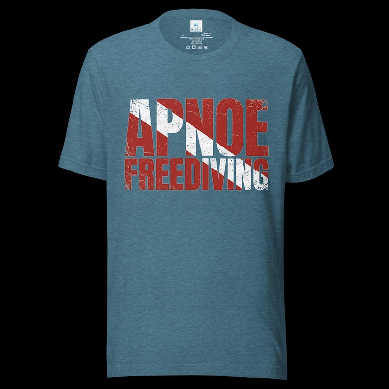 Puede incluir: Una camiseta de manga corta en azul jaspeado con el texto APNOE FREEDIVING en una fuente roja desgastada. Las letras est&aacute;n superpuestas con un patr&oacute;n de rayas diagonales blancas, imitando el dise&ntilde;o de una bandera de buceo en el pecho.