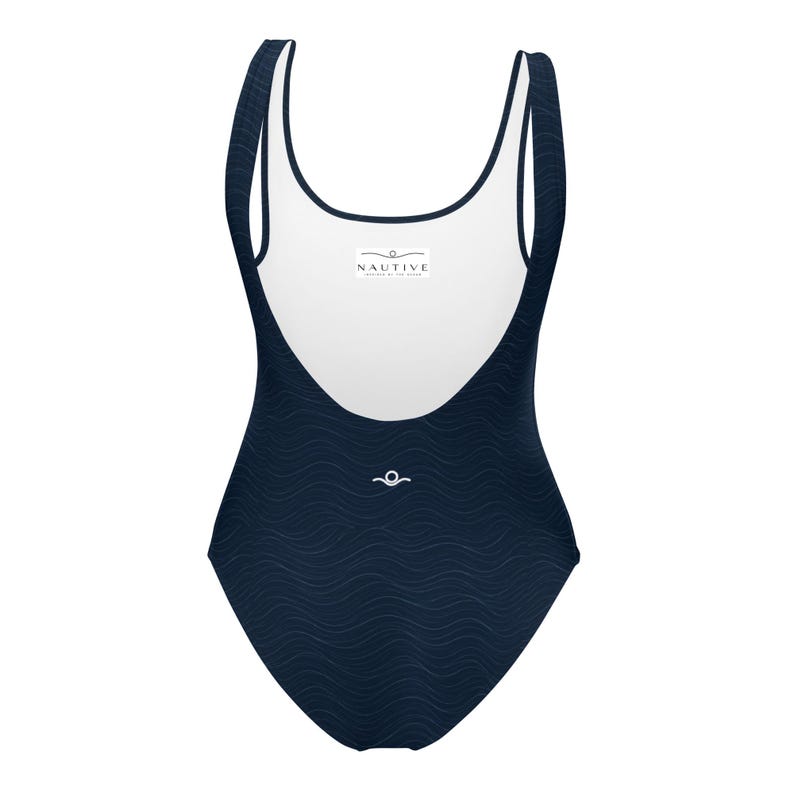 Könnte beinhalten: Ein einteiliger Badeanzug aus dunkelblauem Stoff mit einer dezenten Wellenstruktur. Der Text lautet CURRENT COLLECTION INSPIRED BY THE OCEAN, 4 OCEAN INSPIRED COLORS, MIDNIGHT BLACK, MIDNIGHT NAVY, OCEAN GREEN, SAND und NAUTIVE.