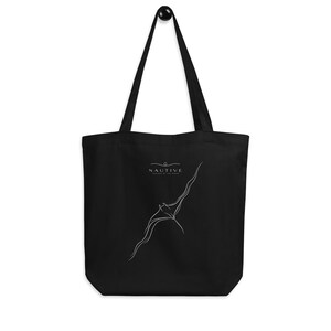 May include: A black tote bag featuring a white line art illustration of a manta ray swimming upward. Above the manta ray, the text NAUTIVE is printed in white, with a small decorative line element positioned directly above the word.