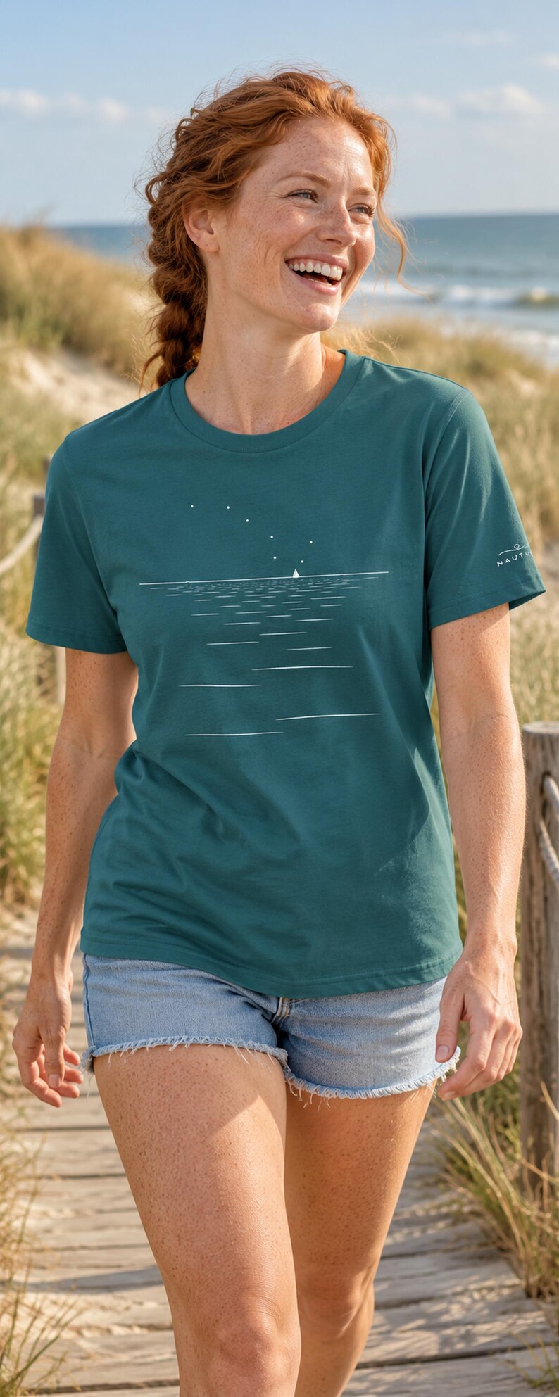 Peut inclure: Un t-shirt &agrave; col rond et manches courtes de couleur sarcelle, orn&eacute; d'un motif graphique blanc repr&eacute;sentant un voilier sur l'eau sous un ciel &eacute;toil&eacute;. Le v&ecirc;tement pr&eacute;sente un petit logo blanc sur la manche gauche et une coupe droite classique.