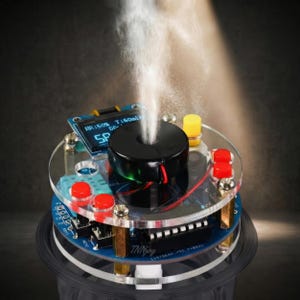May include: A close-up of a black and clear electronic device emitting a vapor stream. The device has a digital display showing "HR:50% T:60ml" and the letters "SP". It features red and yellow buttons and is labeled "TNNjoy".
