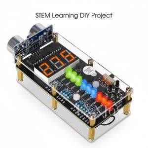 May include: A STEM learning DIY project with a clear acrylic case. The device features a digital display showing "8.8.8", multiple colored LED lights, and various electronic components. The text "STEM Learning DIY Project" is visible.