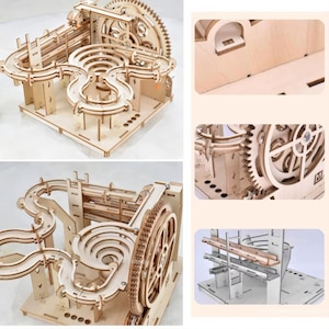 May include: A wooden marble run kit, featuring a complex track design with gears, ramps, and curves. The natural wood color highlights the intricate construction. The kit includes a large gear wheel and multiple levels for the marbles to travel through.