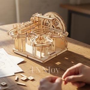 May include: A wooden marble run kit with a complex track design, including loops and a large gear. The kit is made of light-colored wood and is partially assembled. The text "TNNJoy" is visible on the base.
