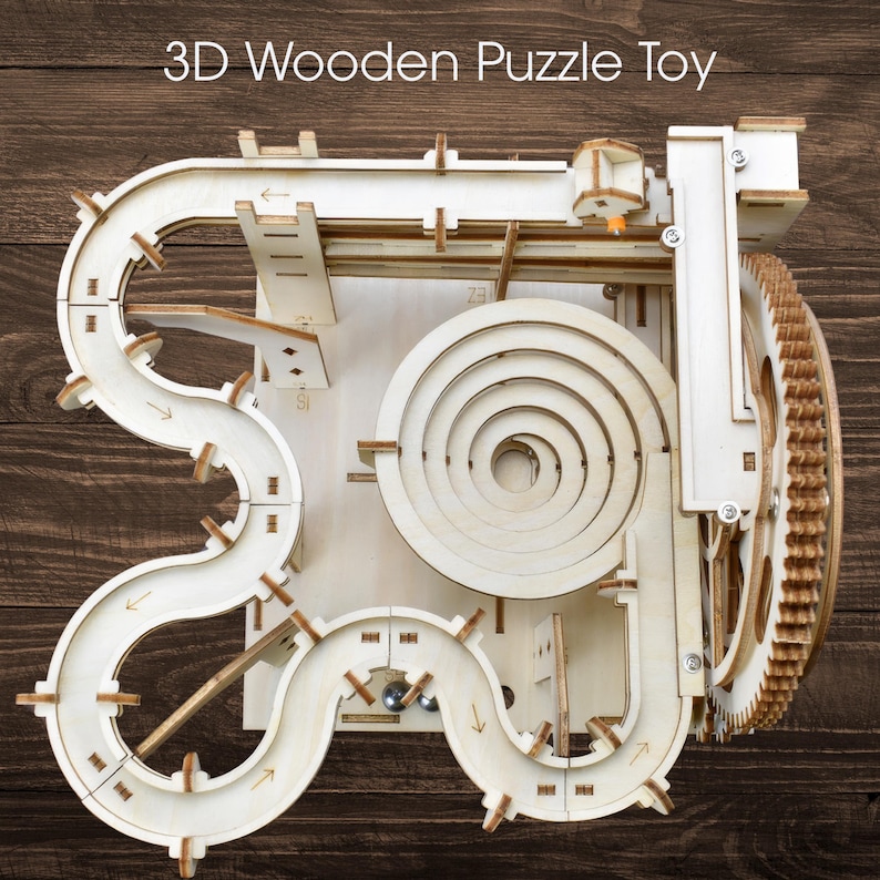 May include: A 3D wooden puzzle toy with the text "3D Wooden Puzzle Toy" at the top. The toy features a complex track with a spiral, ramps, and a gear mechanism. The track is made of light-colored wood, with a few metal marbles visible.